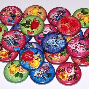 May include: A collection of round, flat buttons featuring vibrant floral patterns with roses and butterflies. The buttons display various colors including red, pink, blue, green, and yellow, each with a detailed rose print and a glossy finish.