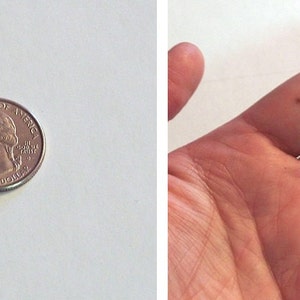 May include: The back of a round button with a metal pin and a black border. The button is about the size of a US quarter.