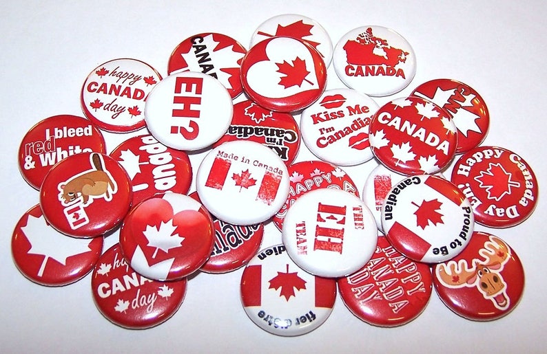 K&ouml;nnte beinhalten: Eine Sammlung von 18 roten, wei&szlig;en und blauen Anstecknadeln mit verschiedenen kanadischen Designs. Die Nadeln zeigen Texte wie "Happy Canada Day", "EH?", "Kiss Me I'm Canadian" und "Made in Canada".