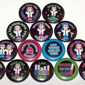 May include: A set of 13 round black button badges with various colorful designs and text. The badges feature a cartoon image of a person wearing a lab coat and goggles. The text on the badges includes phrases like "Lab Tech Girl", "Lab Techs Rock", "World's Best Lab Tech", and "Lab Techs Are So Vein".