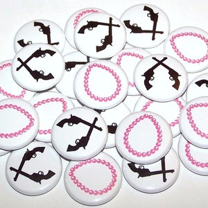 May include: A collection of white round buttons with black silhouettes of crossed pistols and pink pearl necklaces.