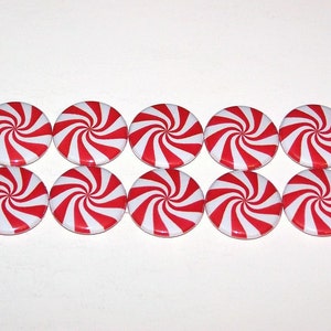 May include: Eight red and white candy cane swirl design buttons. The buttons are round and have a shiny finish.