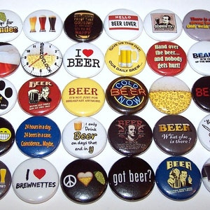 May include: A collection of thirty circular pin-back buttons featuring various beer-themed graphics and slogans. The designs include illustrations of beer glasses, hops, and text such as I hop for blondes, Beer Lover, and Beer is proof that God loves us.