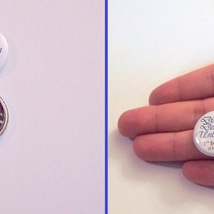 K&ouml;nnte beinhalten: Zwei wei&szlig;e runde Kn&ouml;pfe mit schwarzem Text. Der gr&ouml;&szlig;ere Knopf ist 1,5 Zoll gro&szlig; und tr&auml;gt die Aufschrift "Distinct Designs Unlimited 1,5" button (3,81 cm)". Der kleinere Knopf ist 1 Zoll gro&szlig; und tr&auml;gt die Aufschrift "Distinct Designs Unlimited 1" button (2,54 cm)".