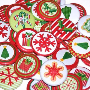 May include: A collection of 1.5 inch round Christmas themed buttons with various designs, including snowflakes, Christmas trees, presents, and holly. The buttons are red, green, and white.