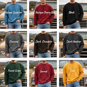May include: A collection of crewneck sweatshirts in various colors, including Antique Sapphire, Antique Cherry Red, Black, Charcoal, Dark Chocolate, Dark Heather, Forest Green, Garnet, and Gold. Each sweatshirt is displayed on a person wearing blue jeans.