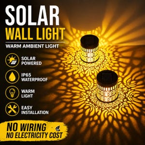 Könnte beinhalten: Zwei solarbetriebene Wandleuchten mit warmem Umgebungslicht. Die schwarzen zylindrischen Leuchten haben ein dekoratives Blumenmuster, das komplizierte Schatten wirft. Text auf dem Bild lautet: "SOLAR WALL LIGHT", "SOLAR POWERED", "IP65 WATERPROOF", "WARM LIGHT", "EASY INSTALLATION", "NO WIRING NO ELECTRICITY COST".