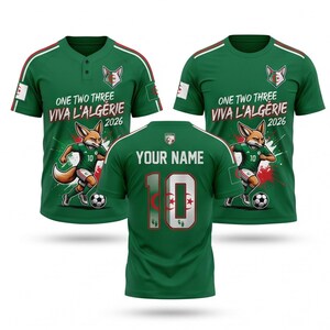 Peut inclure: Maillot de football vert avec des détails blancs et rouges. Le devant présente un renard, le texte "ONE TWO THREE VIVA L'ALGÉRIE 2026" et le numéro 10. Le dos porte le texte "YOUR NAME" et le numéro 10.