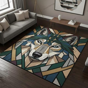 May include: A rectangular rug with a geometric wolf design. The rug features a black border and a colourful pattern of green, blue, grey, and tan geometric shapes. The wolf's eyes are blue.