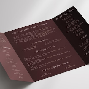 Könnte beinhalten: Eine dreifach gefaltete Hochzeitseinladung in Burgunder- und Weißtönen. Die Einladung enthält Details über Braut und Bräutigam, die Hochzeitsgesellschaft und den Zeitplan der Veranstaltung. Der Text ist in einer zarten, eleganten Schriftart.