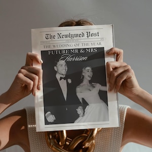 Könnte beinhalten: Eine Person hält eine Zeitung mit dem Titel "The Newlywed Post" mit einem Hochzeitsfoto. Die Schlagzeile lautet "The Wedding of the Year" und "Future Mr & Mrs Harrison". Eine große goldene Kette ist sichtbar.