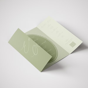 Op de afbeelding: Een lichtgroene, drievoudig gevouwen brochure met de woorden "Wine Room" in een scriptlettertype. De brochure is open en onthult het interieurontwerp en het menu. De achtergrond is wit.