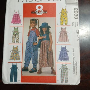 May include: McCall's sewing pattern featuring children's clothing designs. The pattern includes options for dresses and overalls. The cover displays illustrations of the finished garments, with the text "GREAT LOOKS 1 EASY PATTERN".