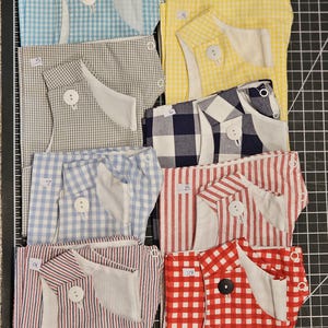 May include: Ten different fabric pieces with numbers 1 through 10 on them. The fabrics are all different patterns, including gingham, stripes, and polka dots. The fabrics are all white with different colored patterns.