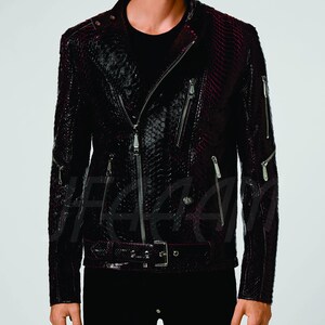 May include: A dark burgundy and black leather jacket with a snakeskin pattern. The jacket features a classic biker style with a diagonal zip, multiple zipped pockets, and a belt at the waist. The jacket has silver hardware.
