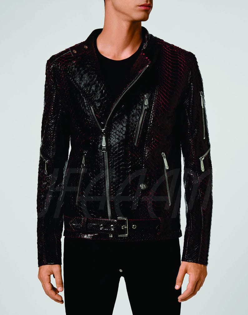 May include: A dark burgundy and black leather jacket with a snakeskin pattern. The jacket features a classic biker style with a diagonal zip, multiple zipped pockets, and a belt at the waist. The jacket has silver hardware.