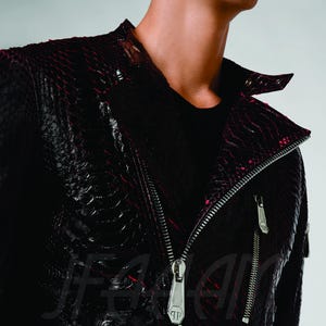 May include: A black and red leather jacket with a snakeskin pattern. The jacket has a silver zip and two silver zipped pockets. The collar is a classic biker style.
