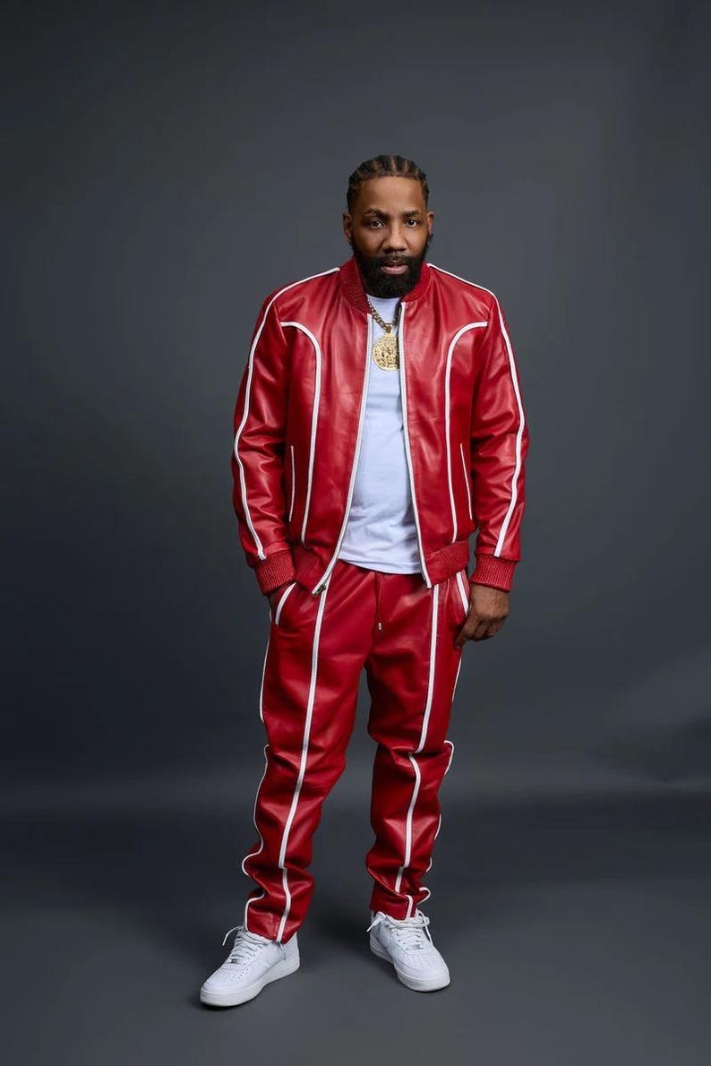 May include: A red leather tracksuit with white trim. The jacket has a zipper closure and ribbed cuffs and hem. The matching pants have a straight leg design. The outfit is paired with white sneakers. The person is wearing a gold chain.