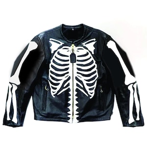 May include: Black leather jacket with a white skeleton design across the front and sleeves. The jacket has a zip closure and two front pockets. A distinctive and bold outerwear item.