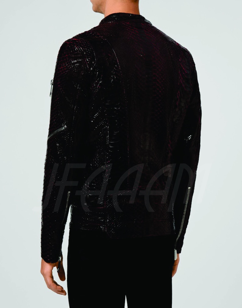 May include: A dark burgundy leather jacket with a textured pattern and silver zips. The jacket has a classic biker style with a high collar and long sleeves. The back view shows the jacket's details, including the zip pockets and seams.