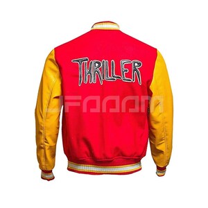 Michael Jackson Thriller Varsity Jacket – Iconic 1980s pop music video costume. Red wool bomber jacket with yellow premium leather sleeves, featuring "Thriller" embroidered text on the back, striped ribbed trim, and a retro preppy look.