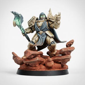 May include: A miniature figurine of a warrior in tan armor and a blue hooded cloak, standing on a rocky red base. The figure holds a staff with a glowing green wing-shaped top and has glowing green eyes, with one hand raised in a gesture.