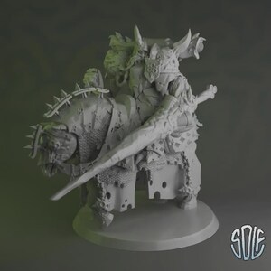 May include: A detailed, grey miniature figure of a warrior riding a beast, possibly for tabletop gaming or display. The warrior is armoured and wields a large sword. The beast is also armoured, with spiked details. The figure is on a round base.