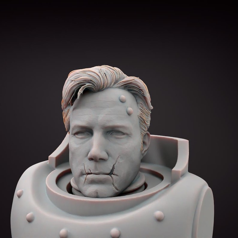 May include: A grey bust of a man with short, styled hair and a stern expression. The bust features a detailed face with visible cracks and rivets on the armor-like structure around the neck and shoulders. The sculpture has a weathered appearance.