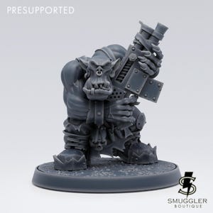 Peut inclure: Miniature grise pré-supportée d'une créature ressemblant à un orc tenant une grosse arme à feu. La figurine est détaillée avec une armure, des bottes et un visage grimaçant. La base est ronde, avec le logo Smuggler Boutique.