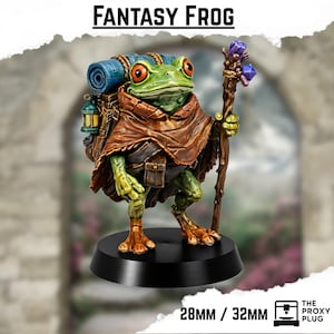 Puede incluir: Figura detallada de un personaje de rana de fantasía. La rana es verde con ojos naranjas, lleva una capa marrón y una mochila. Sostiene un bastón con cristales morados. La base es negra, con el texto "FANTASY FROG".
