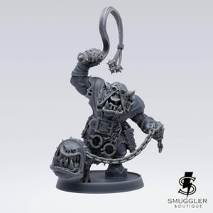 May include: A grey, 3D-printed miniature figure of a fantasy orc character, holding a whip and a chain attached to a dog-like creature. The orc is wearing armour and has a menacing expression. The base is round.