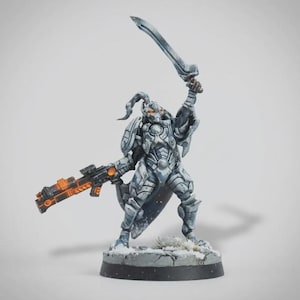 Puede incluir: Figura en miniatura de un guerrero futurista con armadura plateada y azul, empuñando una espada y un rifle con detalles en naranja. La figura está posada dinámicamente sobre una base nevada, mostrando detalles intrincados.