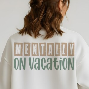 Back of white sweatshirt featuring beige and green mentally on vacation text.