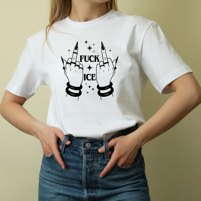 May include: White t-shirt with a black graphic of two hands giving the middle finger, with the words "FUCK ICE" and star accents. The hands have long, pointed fingernails and are adorned with rings and bracelets.