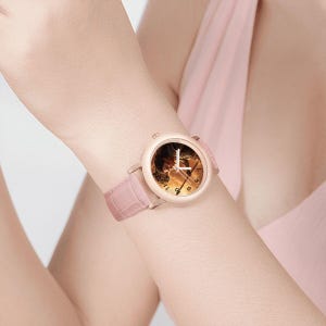 May include: A rose gold wristwatch with a pale pink leather strap. The watch face displays a detailed image with gold hands and hour markers. The strap has a crocodile texture.