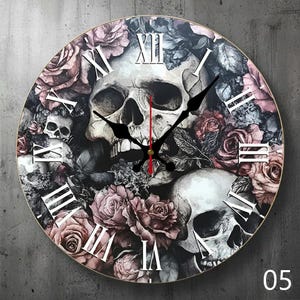 May include: Round wall clock featuring a skull design with roses in shades of pink, gray, and black. The clock has Roman numeral hour markers and black clock hands. The number "05" is in the bottom right corner.