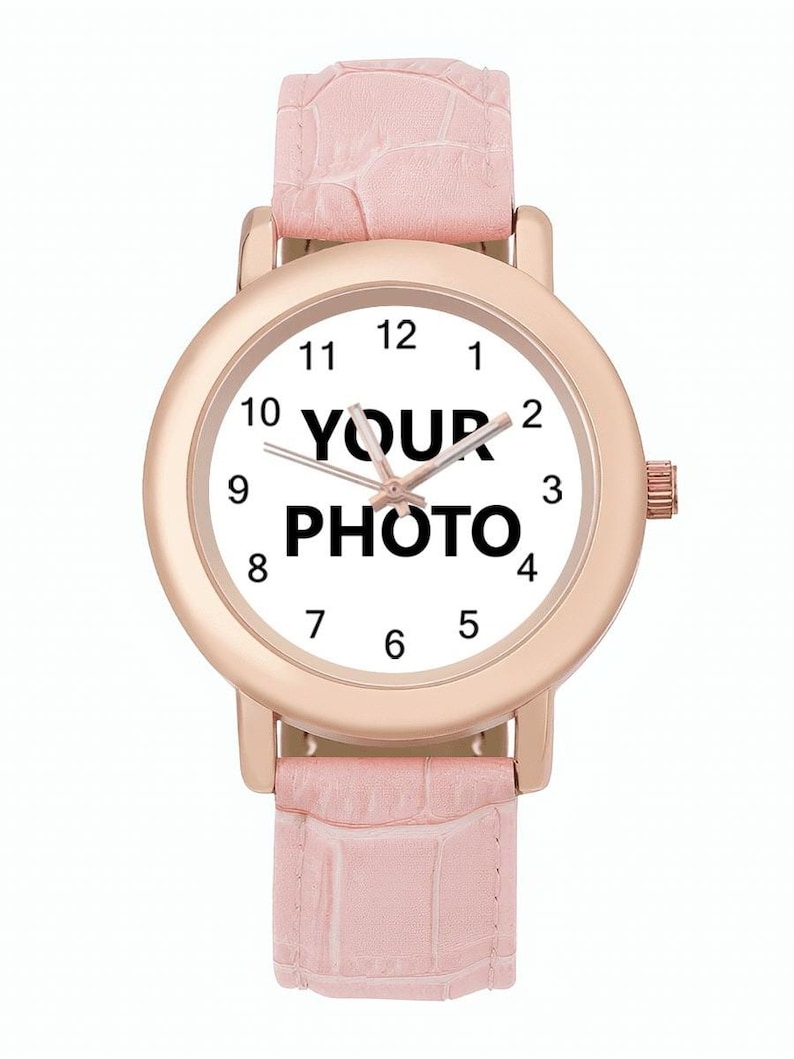 May include: A rose gold wristwatch with a white face displaying the text "YOUR PHOTO". The watch has a pink leather band. The watch face has black numerals and hands.