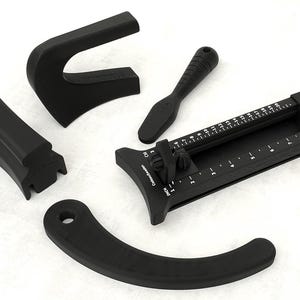 Può includere: Un set di strumenti per cucito e sartoria in plastica nera composto da una guida curva, una piccola impugnatura, un pezzo a blocco e un misuratore rettangolare con cursore scorrevole dotato di contrassegni in pollici e centimetri.