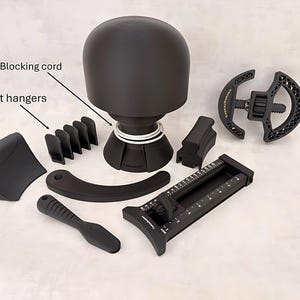 May include: A collection of black hat-making tools, including a hat block, hat hangers, and a measuring tool. The set also includes a blocking cord. The tools are arranged on a light-colored surface.