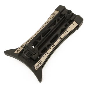 May include: Black and tan measuring tool with inch and centimeter markings. The tool has a curved base and a series of parallel slots. The inch markings are on the right side, and the centimeter markings are on the left side. The tool has a knob at the top.