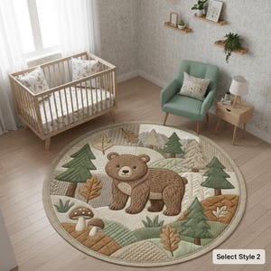 Può includere: Un tappeto rotondo per la cameretta con un orso marrone, alberi e un paesaggio forestale. Il tappeto ha una trama trapuntata con sfumature di marrone, verde e beige. Il tappeto si trova in un ambiente di cameretta con una culla e una sedia.