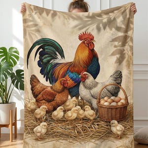 May include: A beige blanket featuring a rooster with vibrant orange, red, and blue plumage, hens, chicks, and a basket of eggs. The blanket has a rustic, farm-themed design, perfect for a cozy home.