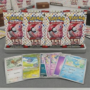 May include: Four Pokemon Trading Card Game booster packs featuring the Scarlet & Violet 151 set, with a pink Mew character on the packaging. Several individual cards are displayed in front, including a Spearow and Horsea card.