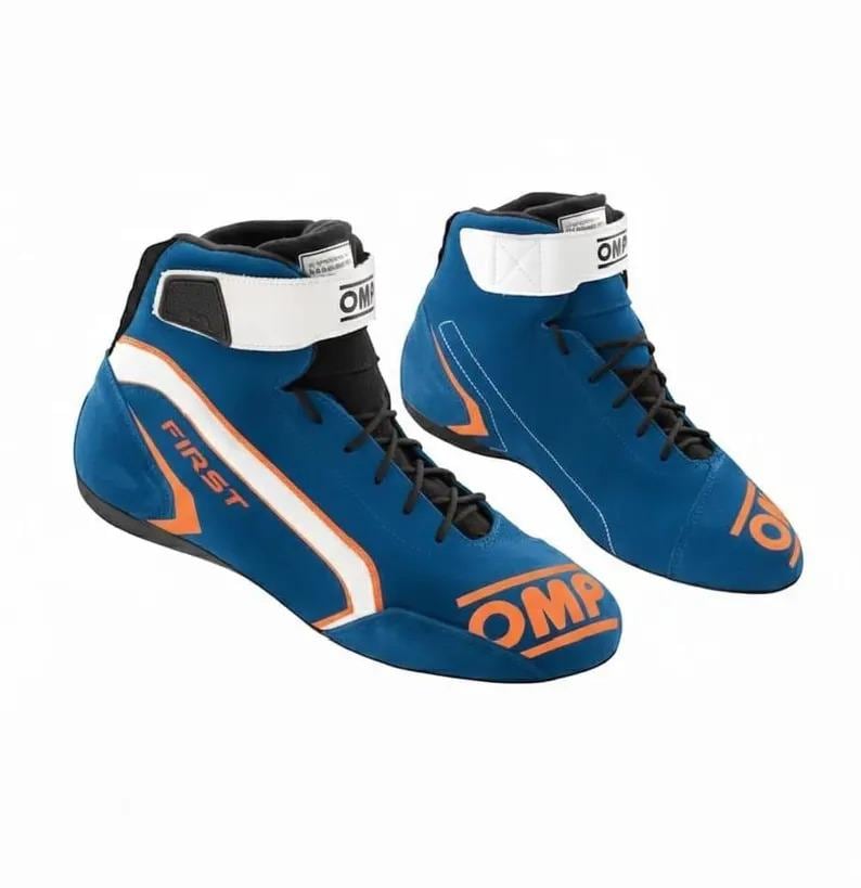 Pode incluir: Um par de sapatos de corrida de cano alto azuis com atacadores pretos, uma tira branca no tornozelo com o log&oacute;tipo OMP e detalhes em laranja. O lado do sapato exibe o texto FIRST em laranja, enquanto a biqueira apresenta o log&oacute;tipo OMP.