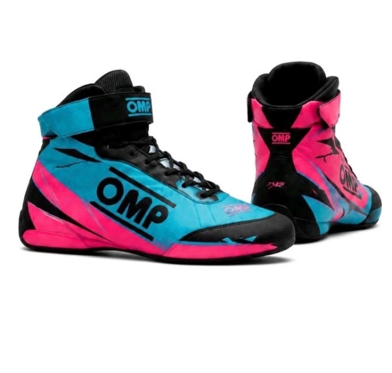 May include: A pair of high-top racing shoes featuring a black, bright blue, and hot pink color scheme. The shoes have black laces, a hook-and-loop ankle strap with the OMP logo, and the OMP brand name printed in black on the side of the shoe.