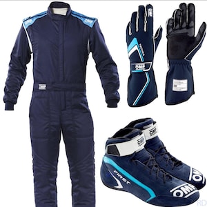 May include: A navy blue racing suit, gloves, and shoes set. The suit has blue and white accents, with the brand "OMP" visible. The gloves are navy blue with white and black details. The shoes are navy blue suede with white straps and accents.