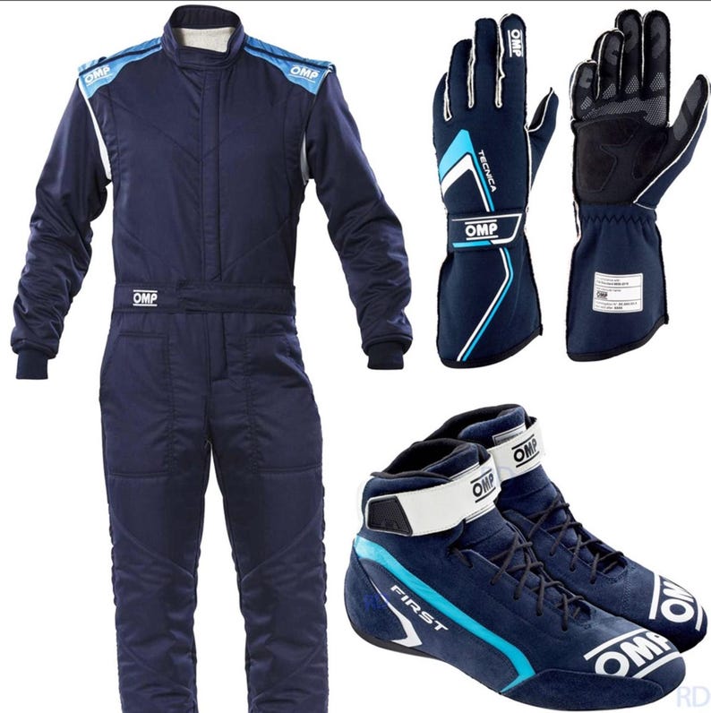 May include: A navy blue racing suit, gloves, and shoes set. The suit has blue and white accents, with the brand "OMP" visible. The gloves are navy blue with white and black details. The shoes are navy blue suede with white straps and accents.