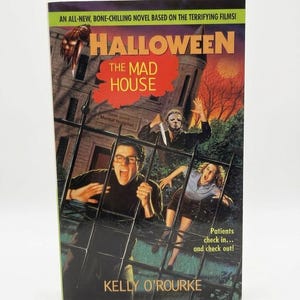 May include: A paperback book titled "Halloween: The Mad House" with a horror movie theme. The cover features a menacing figure with a knife, a spooky building, and the author's name, Kelly O'Rourke.