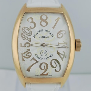 Könnte beinhalten: Eine goldfarbene Franck Muller Crazy Hours Uhr mit weißem Zifferblatt und weißem Lederarmband. Das Zifferblatt zeigt große, stilisierte Ziffern und den Text "Crazy Hours". Die Uhr hat eine diamantbesetzte Zahl 10.