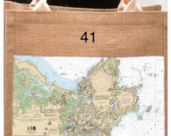 May include: A natural jute tote bag with cream handles. It displays a nautical chart of Cape Ann, Massachusetts, with "Cape Ann" text and an anchor symbol. The number "41" is printed on the bag.